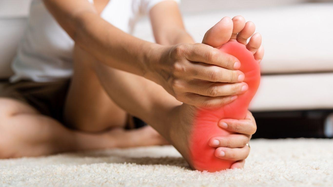 Runner holding heel with plantar heel pain